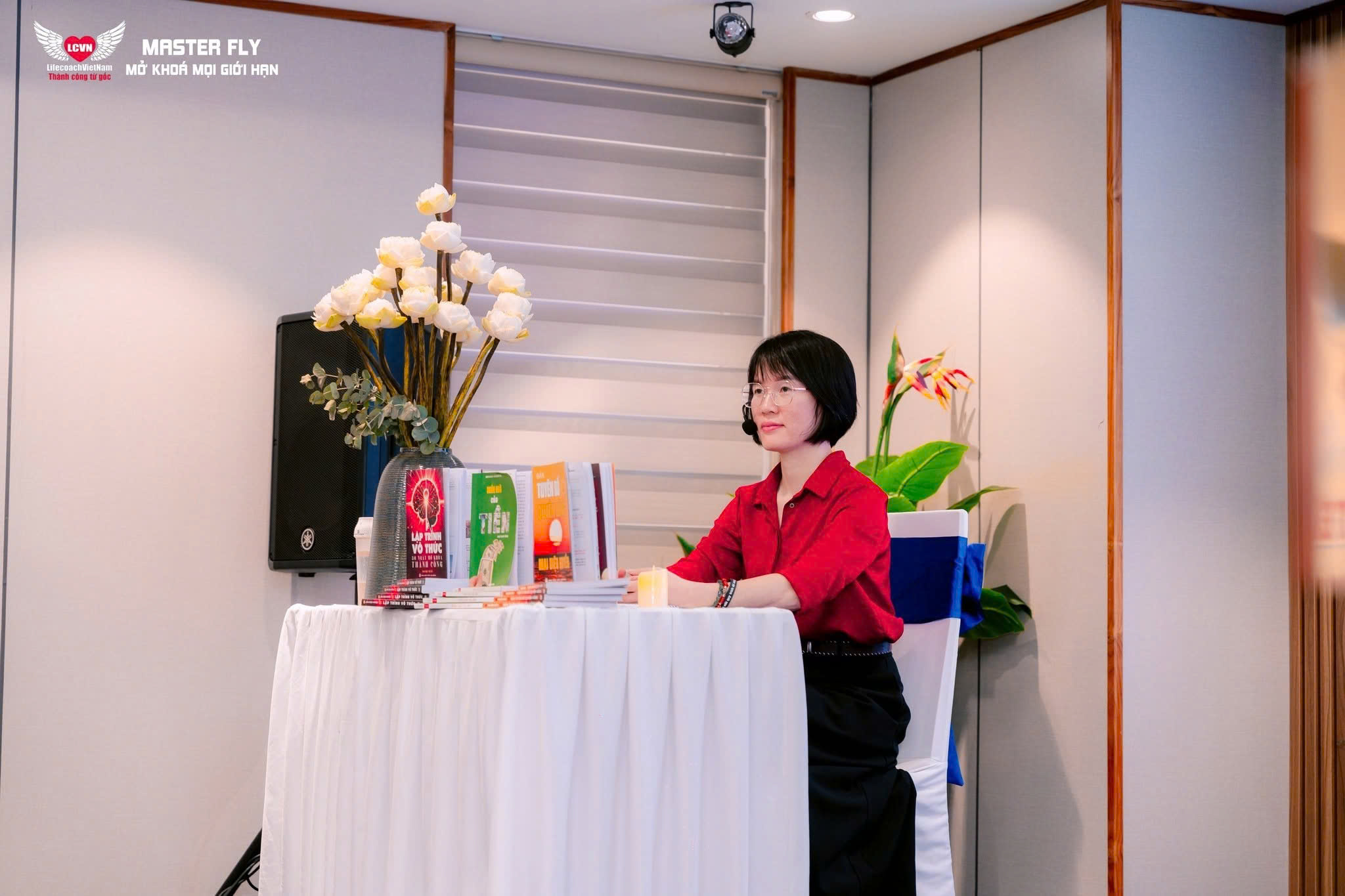 Chị Mai Diệu Huyền bên bàn trưng bày các cuốn sách của mình
